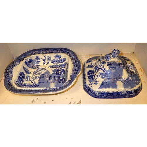 335 - A 19thC willow pattern tureen together with a blue and white pedestal plate and serving dish (3)