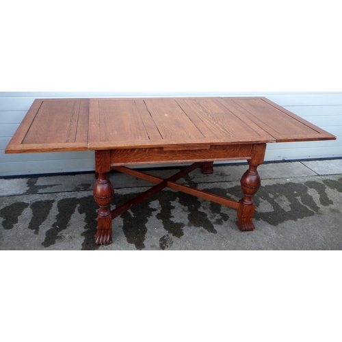 629 - A 1930's oak draw leaf table, 214cm long open