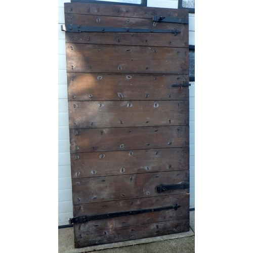 721 - A large oak door with ironwork, stud rivets and vertical and horizontal board construction, 106cm x ... 