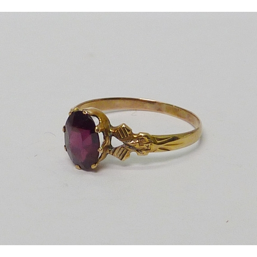 18 - A solitaire ring, unmarked yellow metal set with and oval cut garnet.  Size R.  813894