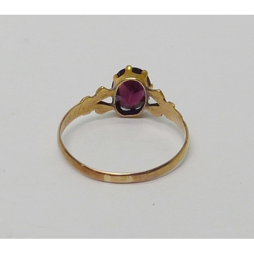 18 - A solitaire ring, unmarked yellow metal set with and oval cut garnet.  Size R.  813894