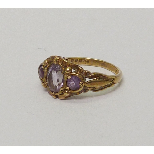 23 - A 9ct gold amethyst three stone ring.  Approximately 3gr gross / size L.   813883