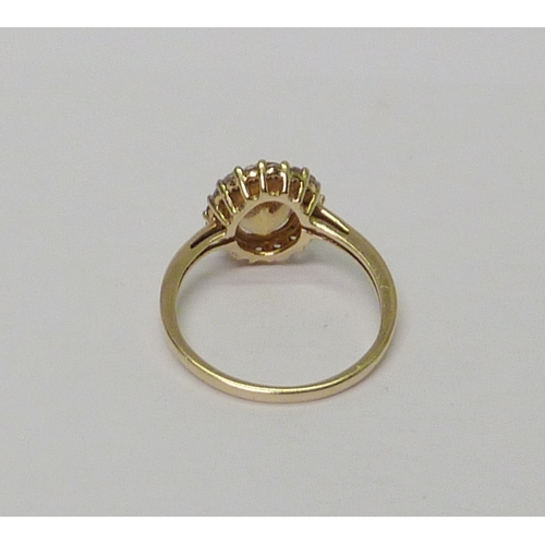 24 - A 9ct gold citrine & clear gemstone halo ring. 
 Approximately 2.5gr gross / size P 1/2. 
735517