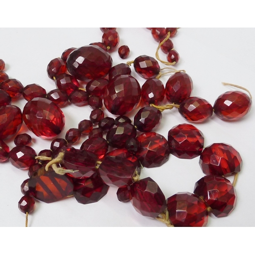 37 - A string of cherry amber coloured bakelite faceted beads, a/f necklace stringing broken; a similar b... 