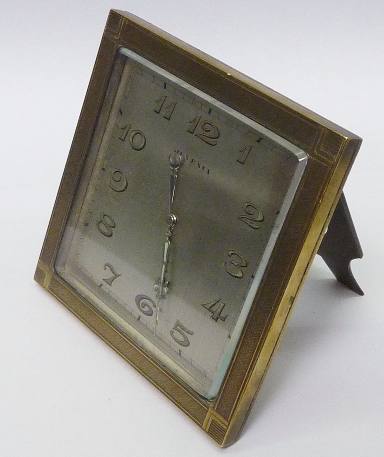 An Ateliers Juvenia desk clock having a silvered dial in a polished