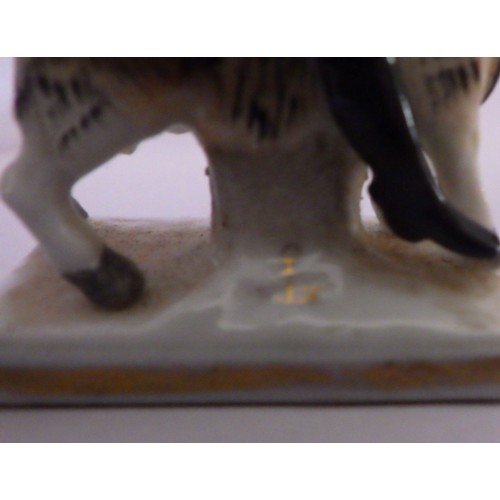 407 - A 19th C small porcelain soldier riding a ram / goat 7cm tall