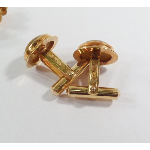 16 - A pair of cufflinks and a matching tie stud, yellow metal marked 18kt set with tiger's eye cabochons... 