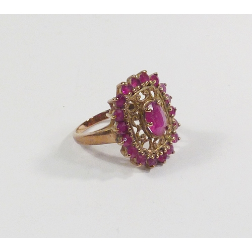 42 - A cluster ring comprising pink tourmaline stones in a 9ct gold setting incorporating a pierced friez... 