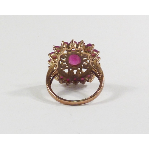 42 - A cluster ring comprising pink tourmaline stones in a 9ct gold setting incorporating a pierced friez... 