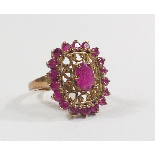 42 - A cluster ring comprising pink tourmaline stones in a 9ct gold setting incorporating a pierced friez... 