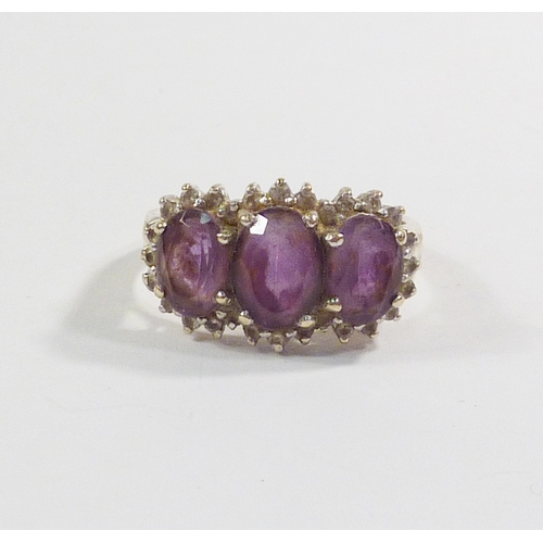 43 - A triple cluster ring comprising three pink amethysts surrounded by a line of diamonds in a 9ct gold... 