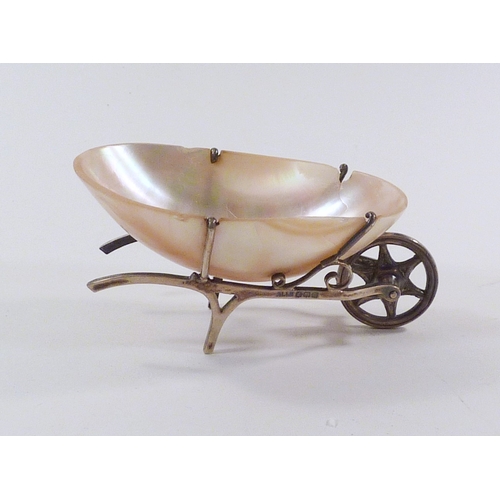 69 - A novelty table salt as a wheelbarrow comprising a seashell in a silver mount, 75mm long, a/f; a sil... 