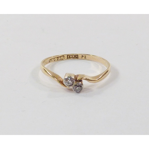 101 - A twist ring comprising two diamonds in a yellow metal setting marked 18ct.  A/F setting worn to sid... 