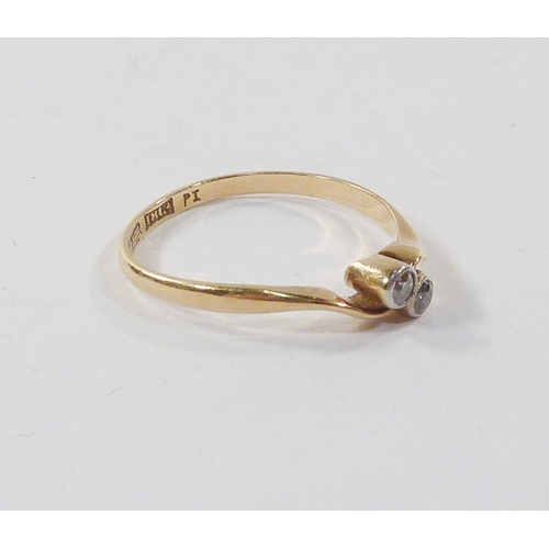 101 - A twist ring comprising two diamonds in a yellow metal setting marked 18ct.  A/F setting worn to sid... 