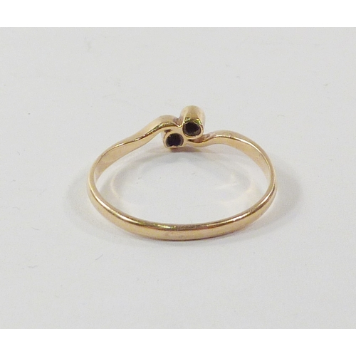 101 - A twist ring comprising two diamonds in a yellow metal setting marked 18ct.  A/F setting worn to sid... 