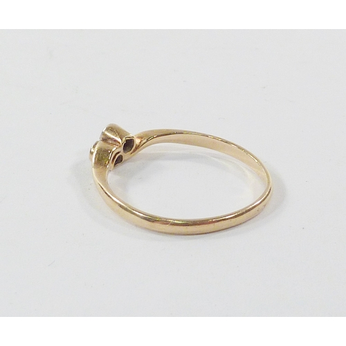 101 - A twist ring comprising two diamonds in a yellow metal setting marked 18ct.  A/F setting worn to sid... 