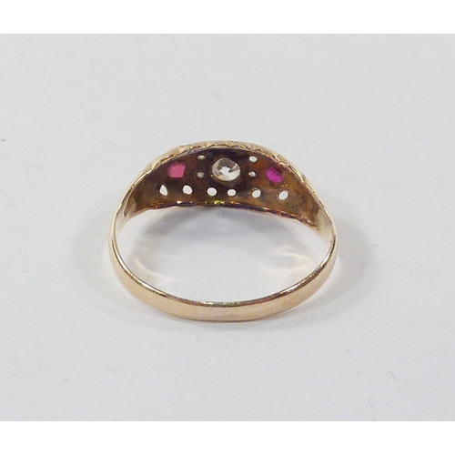 96 - A boat head ring, 18ct gold set with a central paste stone and two red stones the arrangement spaced... 