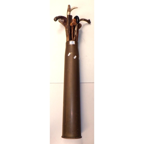 77 - A brass shell case as a stick stand together with a qty of walking sticks.