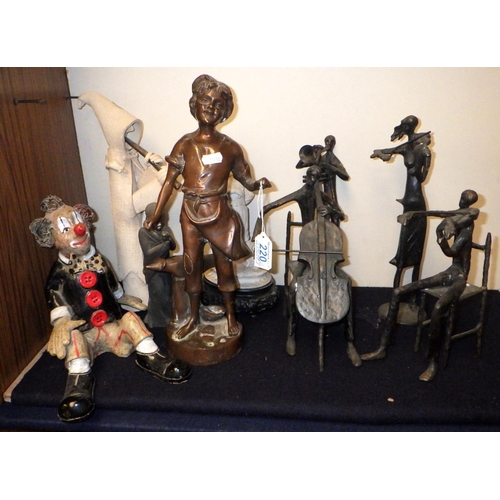 220 - A group of four musician figurines, cast base metal; a figurine of a blacksmith's boy, 36cm tall; a ... 