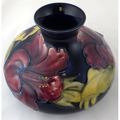 382 - A Moorcroft squat Hibiscus vase with paper label together with a small Moorcroft candlestick (2)