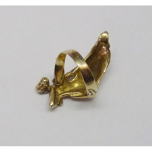 416 - A ring cast with a reclining female figure in classical influence robes, yellow metal marked 14k.  F... 