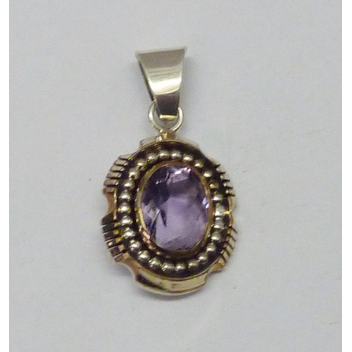 430 - A Lee Bennett Navajo pendant comprising a central synthetic amethyst in a white and yellow metal mou... 