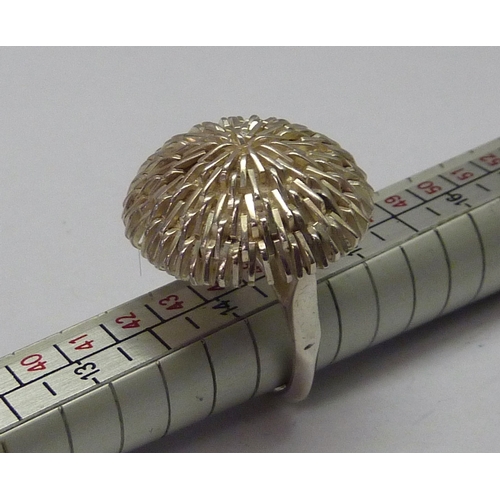 433 - A flower head cocktail ring, white metal marked 925.  23mm diameter.