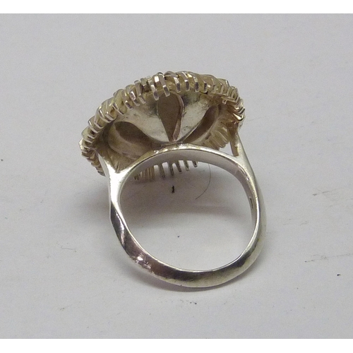 433 - A flower head cocktail ring, white metal marked 925.  23mm diameter.