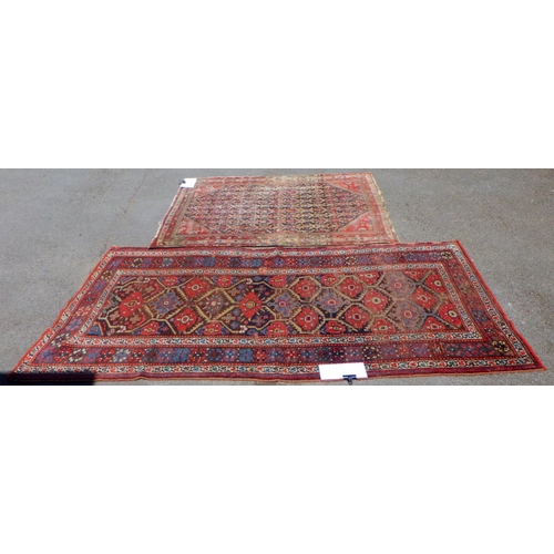 600 - Two Oriental red ground rugs, worn, holes, largest 131cm x 250cm