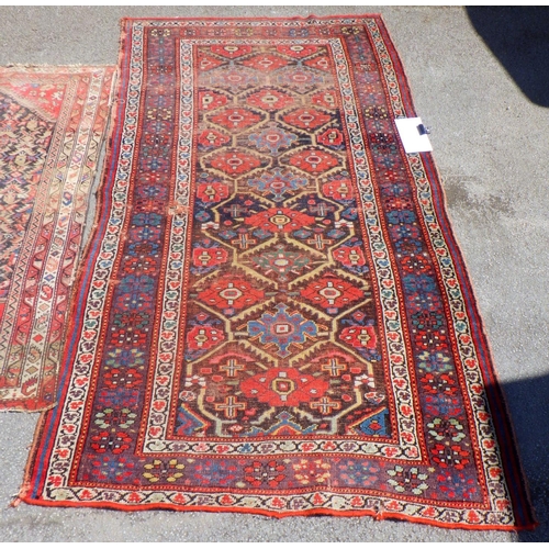 600 - Two Oriental red ground rugs, worn, holes, largest 131cm x 250cm