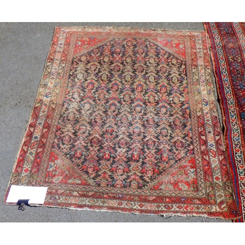 600 - Two Oriental red ground rugs, worn, holes, largest 131cm x 250cm