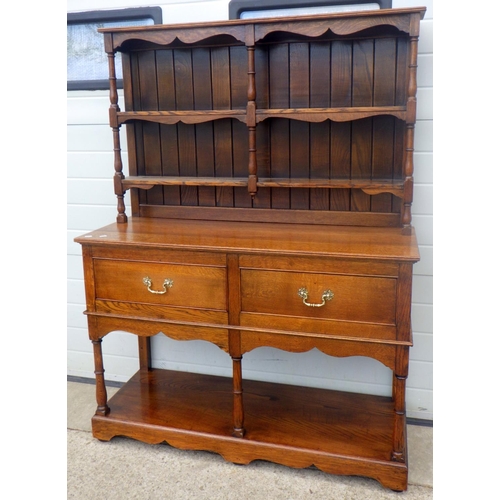 610 - An oak two drawer dresser with pot board and plate rack, 122cm wide