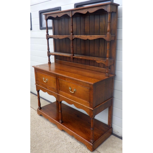 610 - An oak two drawer dresser with pot board and plate rack, 122cm wide