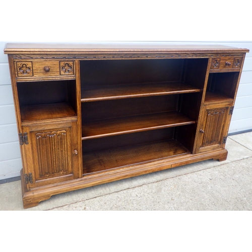 613 - An Old Charm low bookcase with linenfold panelled doors, 151cm wide