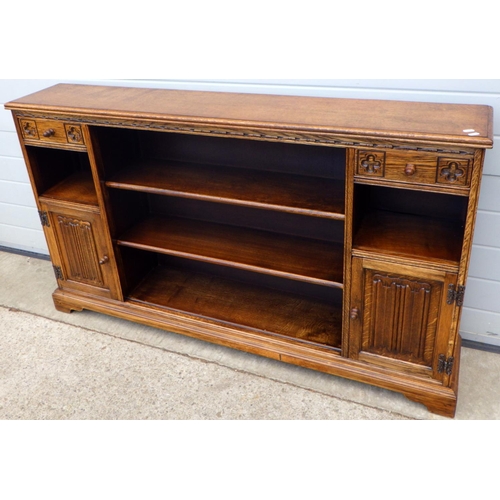 613 - An Old Charm low bookcase with linenfold panelled doors, 151cm wide