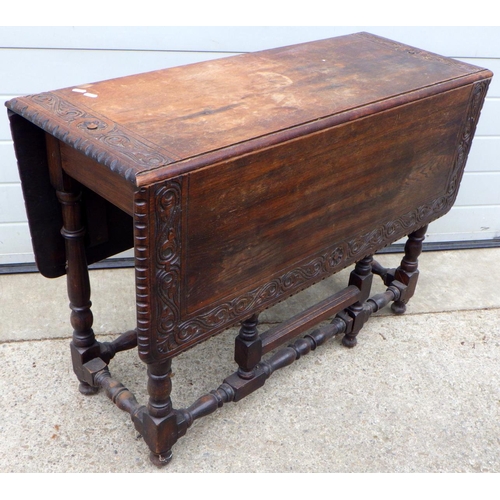 644 - A 1930's oak gateleg table with carved border, 102cm long