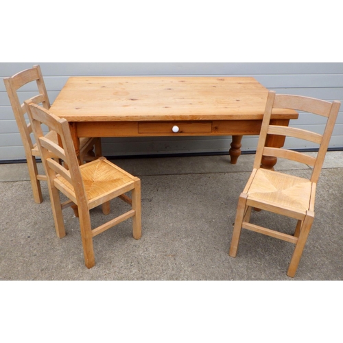 648 - A pine kitchen table with two drawers, 153cm long, legs cracked, together with 3 chairs