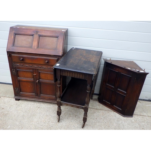 799 - A panelled oak bureau 69cm wide, together with a drop leaf trolley and a hanging corner cupboard (3)