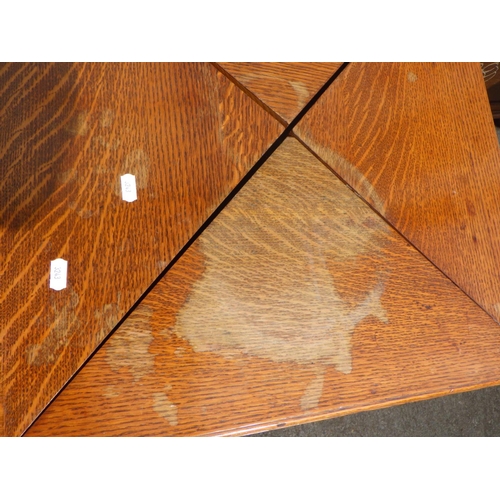 823 - An Edwardian oak envelope card table, top marked, missing handles, together with an oak/ply blanket ... 