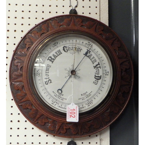 102 - A carved oak Aneroid barometer 34cm diameter