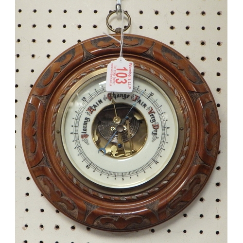 103 - A carved walnut Aneroid barometer 23cm diameter