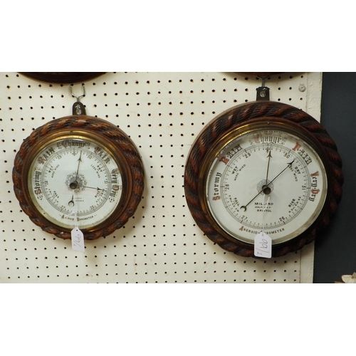 99 - Two carved oak rope twist Aneroid barometers 23 & 26cm diameter (2)