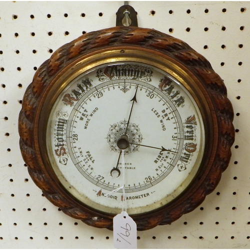 99 - Two carved oak rope twist Aneroid barometers 23 & 26cm diameter (2)