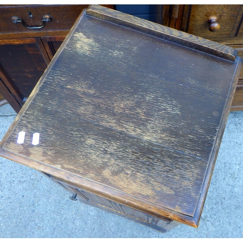 699 - An oak bureau, sliding door bookcase, linenfold bedside cabinet and another cupboard (4)