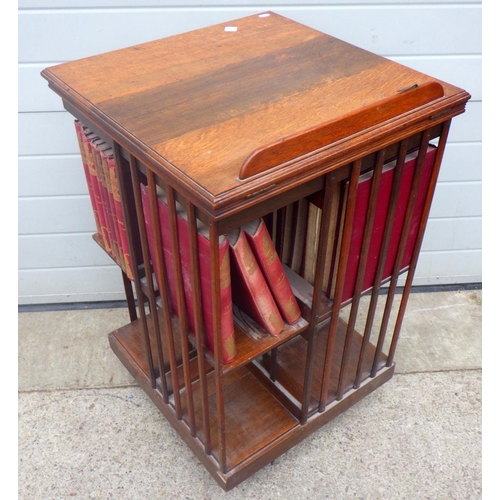 731 - An Edwardian oak revolving bookcase with lecturn top (a/f) together with Punch books, 57cm wide