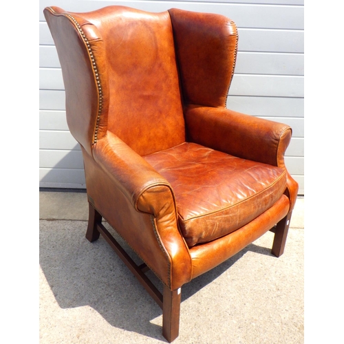 785 - A brown leather wingback armchair, mark to back, with label Halo