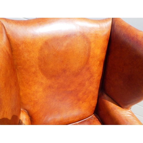 785 - A brown leather wingback armchair, mark to back, with label Halo