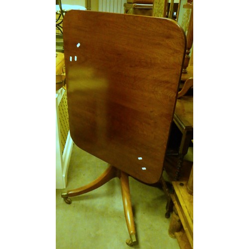 841 - A mahogany tilt top table, castor a/f, 84cm across, together with a suitcase (2)