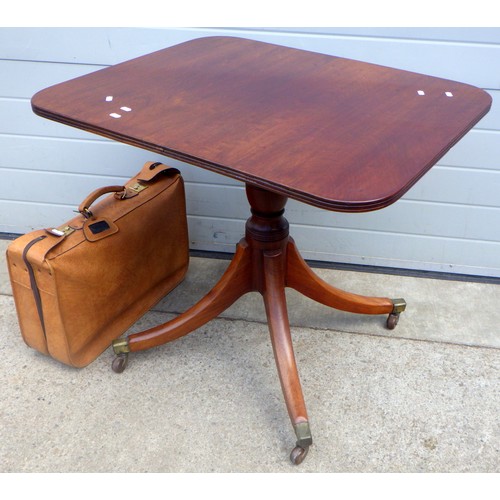 841 - A mahogany tilt top table, castor a/f, 84cm across, together with a suitcase (2)