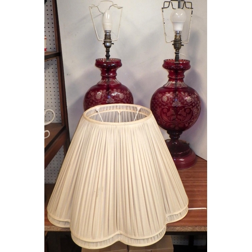 100 - A pair of red-flashed-glass vase-based table lamps with pleated shades.